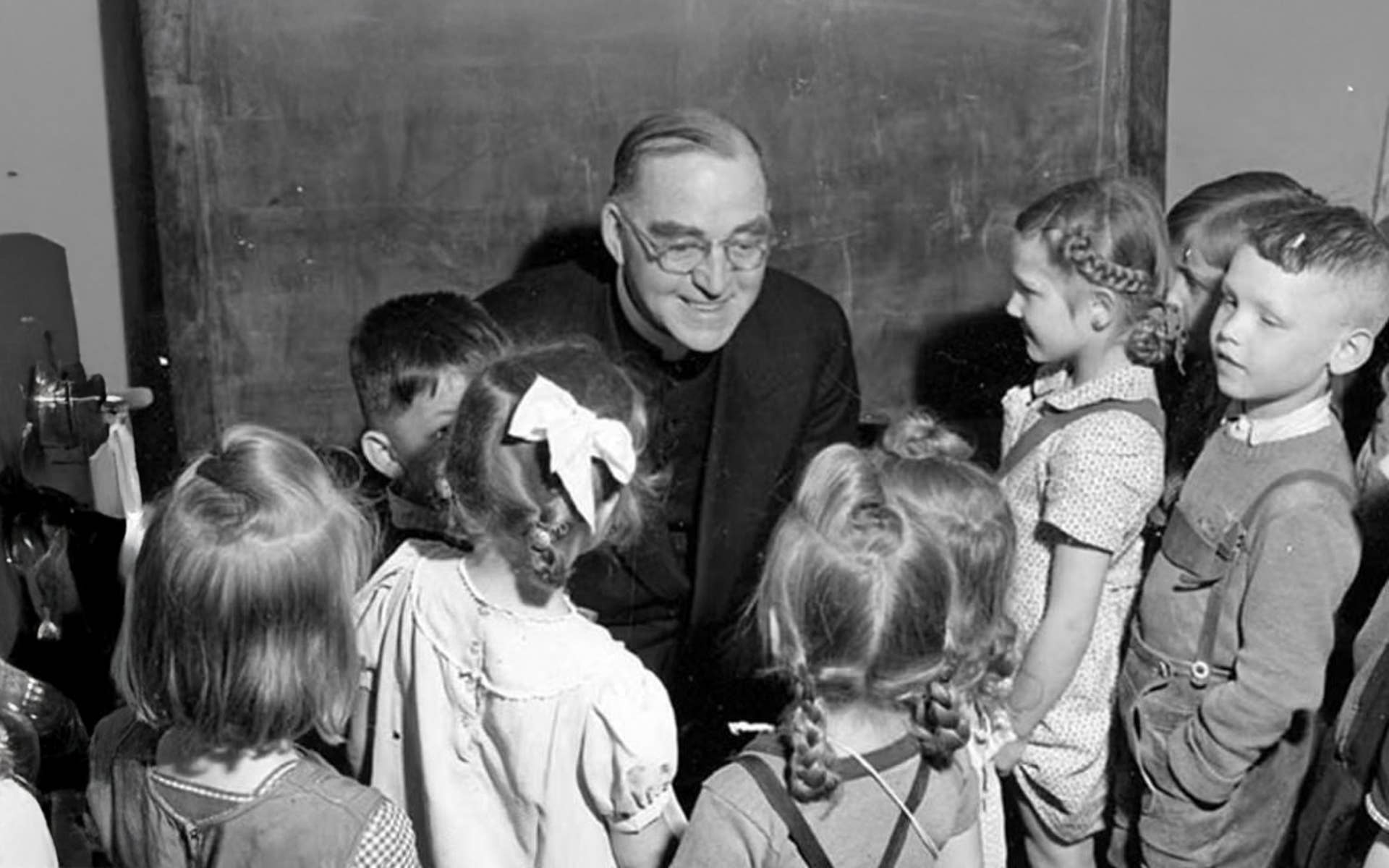 Father Flanagan talking with young kids